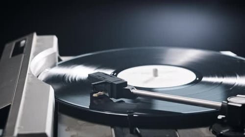 Hand Places Needle on Vinyl Record Player Close Up