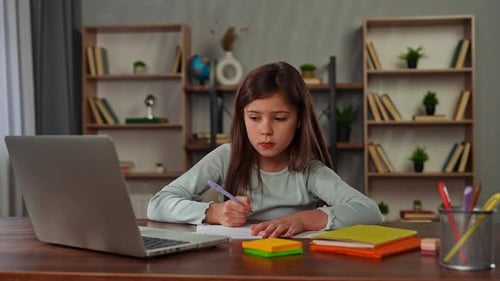Young Child Girl Studying at Home Small Girl Sits at Desk and Attends School Class Online on Laptop