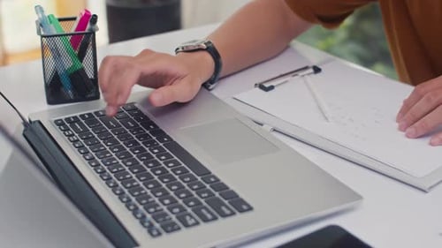 Typing on Laptop, Writing on Clipboard in Office