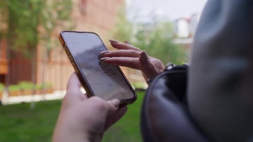 Woman Using Map App on Smartphone in City