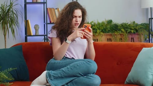 Woman Reacts Negatively to Phone News Indoors
