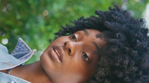 Woman Relaxes with Curly Hair in Nature Close Up
