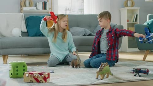 In the Living Room: Boy and Girl Playing with Toy Airplanes and Dinosaurs while Sitting on a Carpet