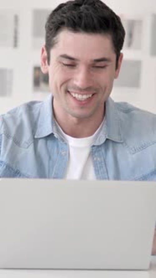 Man Video Conferencing Using Laptop in Bright Room