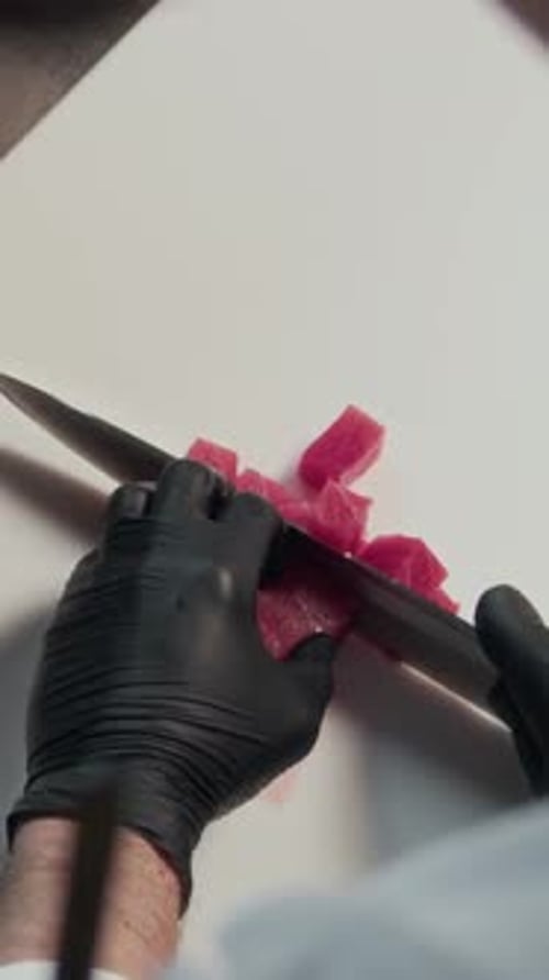 Hands of Chef Cutting Raw Tuna in Restaurant Kitchen