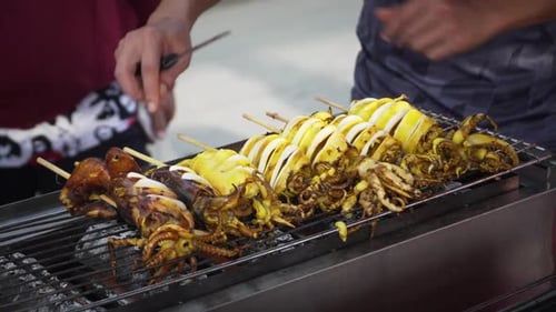 Close up grilling squid on barbecue. Cooking food outside in summer