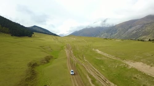 Car driving on the mountain meadow