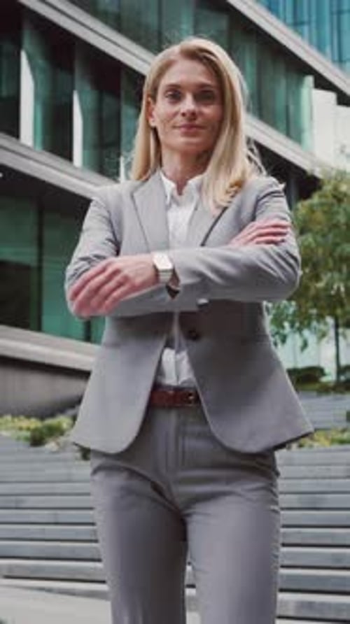 Confident Businesswoman in Gray Suit Smiling Outdoors