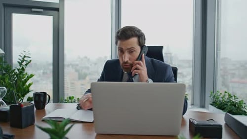 Worried entrepreneur owner phone negotiation in modern office making notes