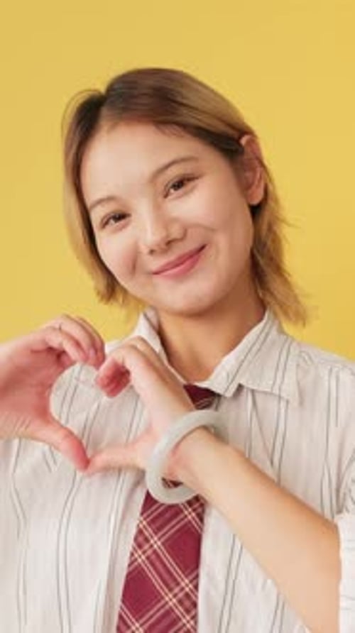 Young Adult Making Heart Shape With Hands