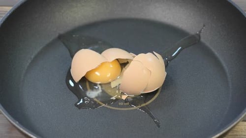 Egg is falling down and breaking on the pan