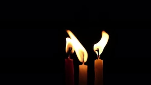 Flamme de bougie soufflant dans le vent
