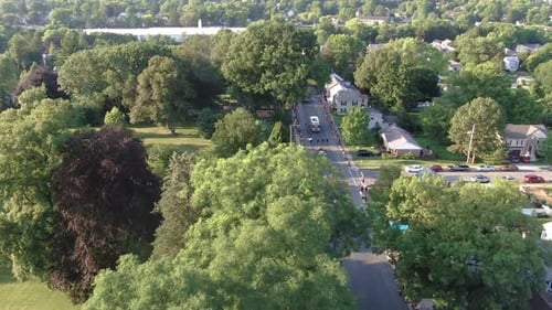 Rising aerial of parade along a tree-lined street in Lititz Lancaster County Pennsylvania, 4th of Ju
