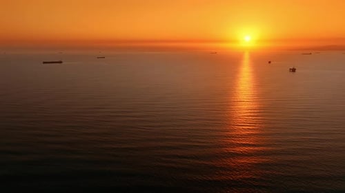 Soleil couchant dans le ciel orange au-dessus du vaste paysage aquatique. Magnifique coucher de soleil au-dessus de l'océan Pacifique.
