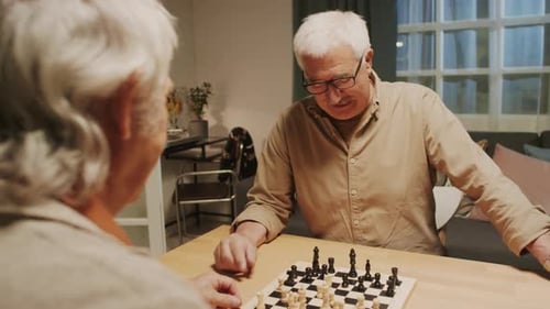 Senior Adults Playing Chess Game at Home