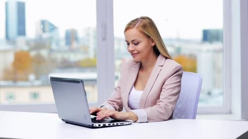 Business, People And Technology Concept - Young Businesswoman With Laptop Computer Typing At Office