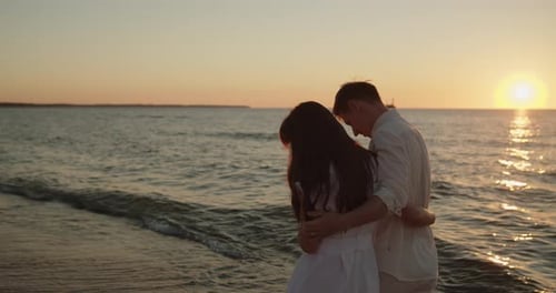 Young Loving Couple Enjoying Relaxing Sunset Walk on the Beach