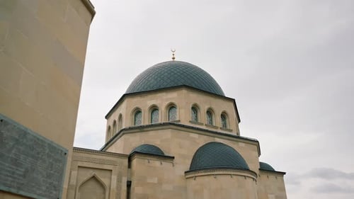 Close-up shot of the gambiz dome with a crescent moon on top of a Muslim mosque against blue sky