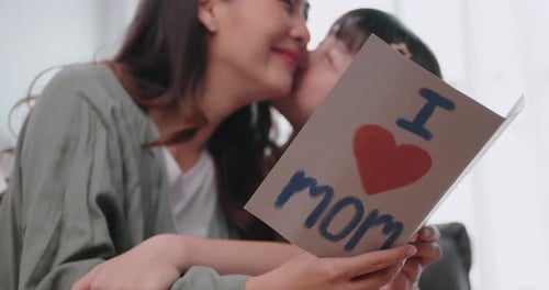 Woman and Child Share Loving Moment with Card