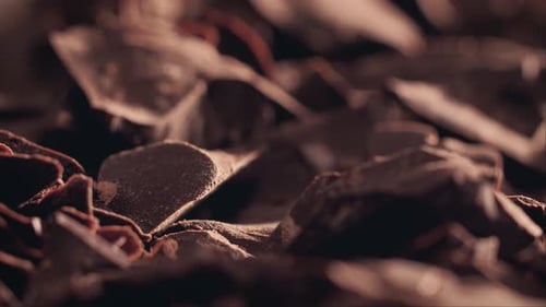 Chunks of sweet dark sliding backdrop, close-up. Gourmet dessert ingredient.