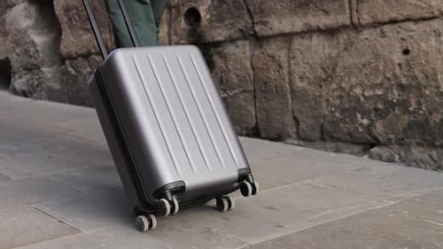 Tourist with Suitcase Baggage in Spain A Traveler with Luggage Strolls Down a Lively City Street to