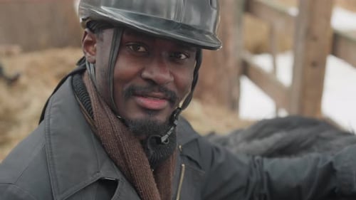 Man Wearing Riding Helmet Smiling at a Farm