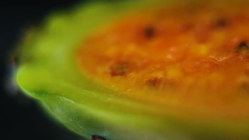 Vídeo detallado de un sabra en rodajas, fruta de cactus tropical abierta de color naranja, movimiento suave de deslizamiento hacia la derecha, sl