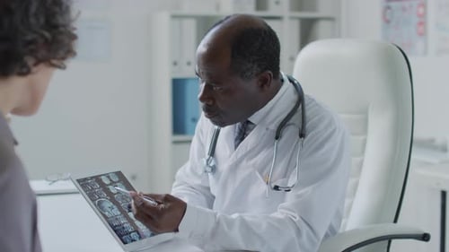 Doctor Reviews Brain Scan with Patient in Office