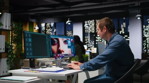Man Works at Dual Screen Computer Late at Night