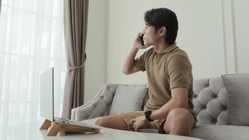Man Using Laptop and Mobile Phone Indoors