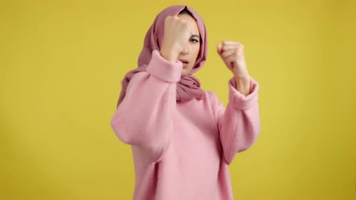 Determined Woman Makes Boxing Gesture in Studio