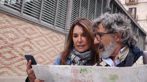 Älteres Paar geht spazieren, schaut sich die Karte an und verwendet den Standort des Mobiltelefons in der Street of City