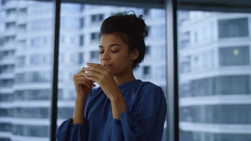 Relaxed african american businesswoman enjoying coffee break in sunny office