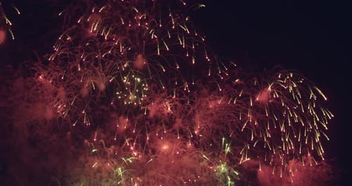 Nahtloser Loop von echtem Feuerwerkshintergrund mit Bokeh-Lichtern am Nachthimmel. Silvester-Feuerwerk