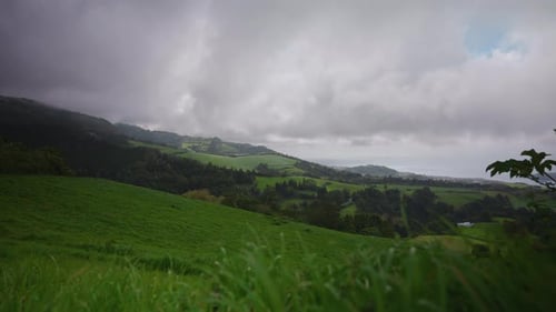 Panoramic view of green lush meadow landscape in the Azores, Cloudy dramatic weather. View of the Co