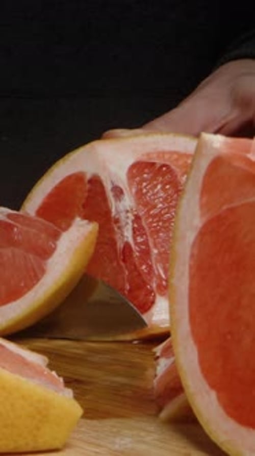 Vertical video. While the camera glides between the grapefruit slices, in the background.