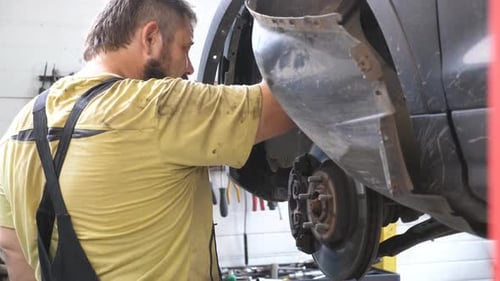 Mechanic Working on Car in Auto Repair Shop