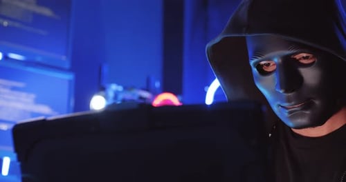Masked Hacker Coding in Dark Room at Night