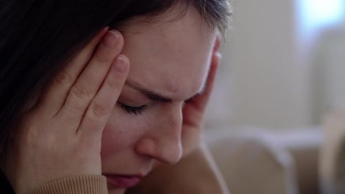 Worried young woman's close up shows pain suffering stress and mental health issues