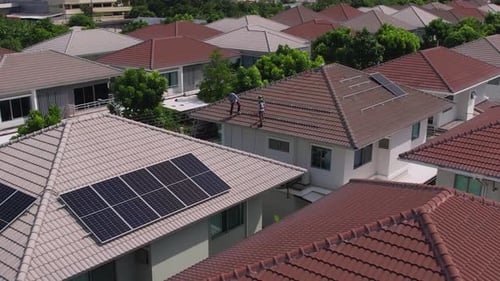 Drone view of engineer worker installed solar panels on roof of house.