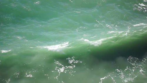 Ocean Wave Surf Rolling and Breaking Into White Foam on the Emerald Sea Surface Showing Powerful