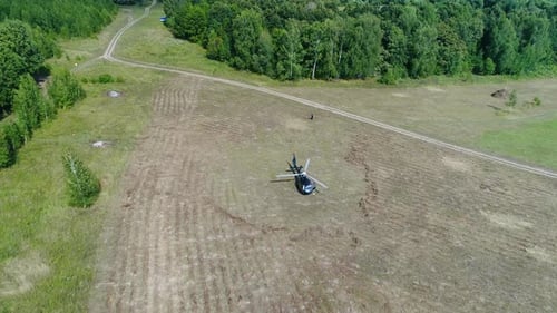 Un hélicoptère atterrit en toute sécurité sur un champ de ferme pittoresque entouré d'une magnifique végétation luxuriante