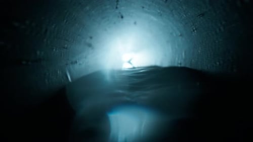 Langer dunkler Abwassertunnel mit fließendem Wasser