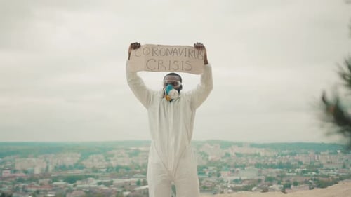 Man in Hazmat Suit Holds Crisis Sign