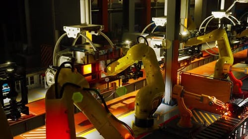 Automatisierte Roboterarme, die auf einem Förderband in einer Produktionsanlage arbeiten