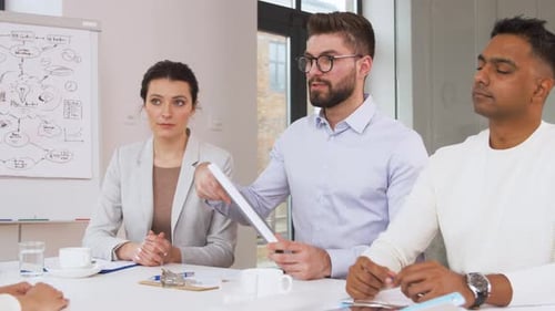 Business Team Meeting Discussing Documents in Modern Office