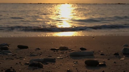 Pebbles on a beach at sunset.