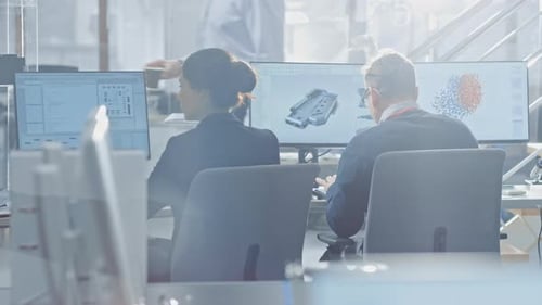 Back View of Team of Technology Engineers Working on Desktop Computers in Bright Office. Screens Sh