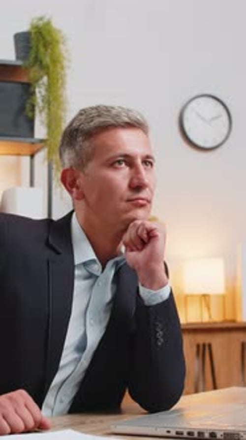Handsome Young Businessman Thinking Business Ideas While Sitting with Laptop at Home Office Desk