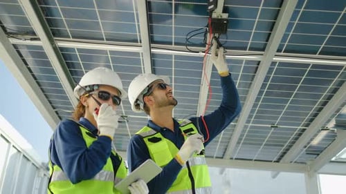 Technicians Inspect Solar Panels at Energy Facility